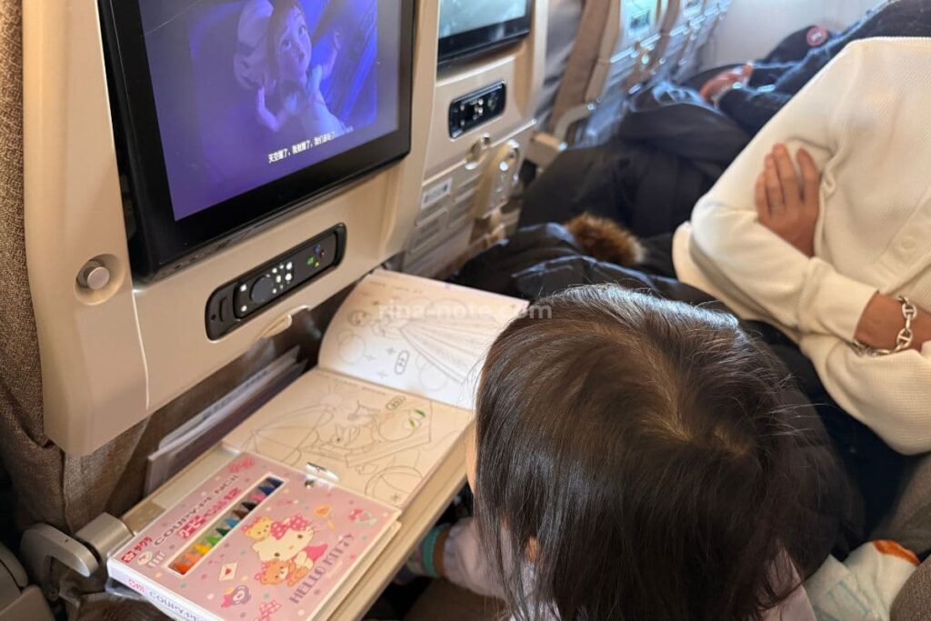 中国東方航空の機内で座席モニターを見ながら過ごす子どもの様子