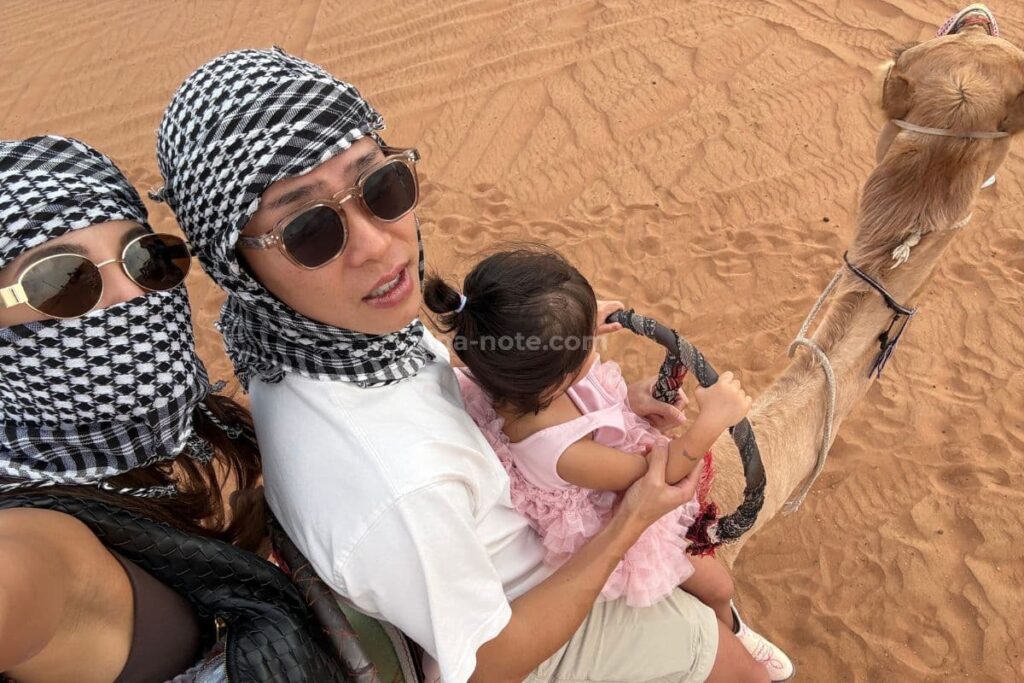 ドバイ砂漠ツアーでラクダに乗る家族のセルフィー