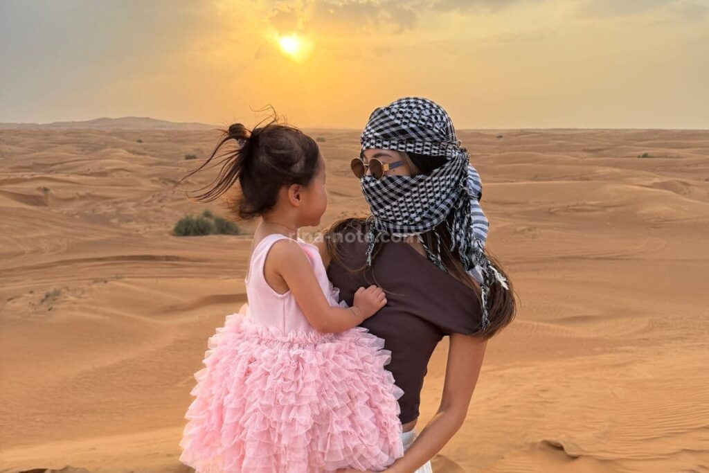 ドバイ砂漠ツアーの砂丘で写真撮影する親子