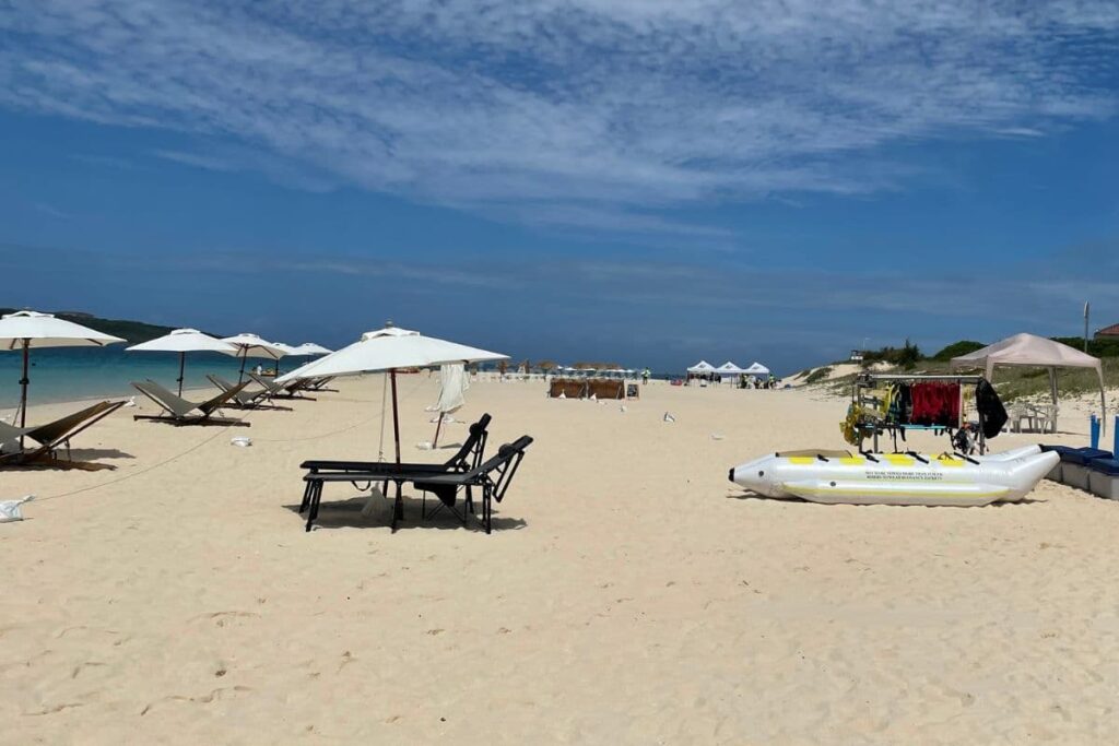 与那覇前浜ビーチのパラソルやビーチベッド、マリンアクティビティショップの様子